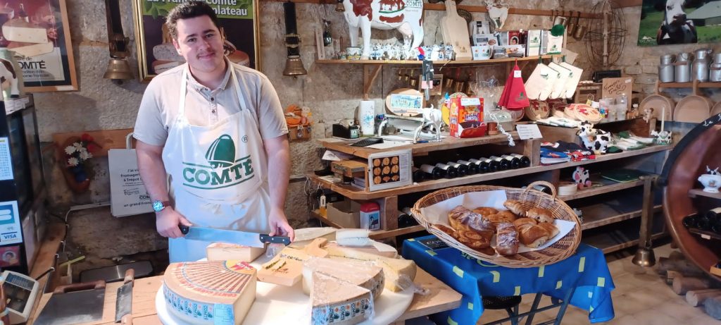 Mattéo dans la fromagerie musé de Trépot coupant du comté