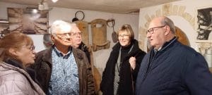 Groupe en visite dans la cave de la Fromagerie-Musée de Trépot devant des meules de Comté